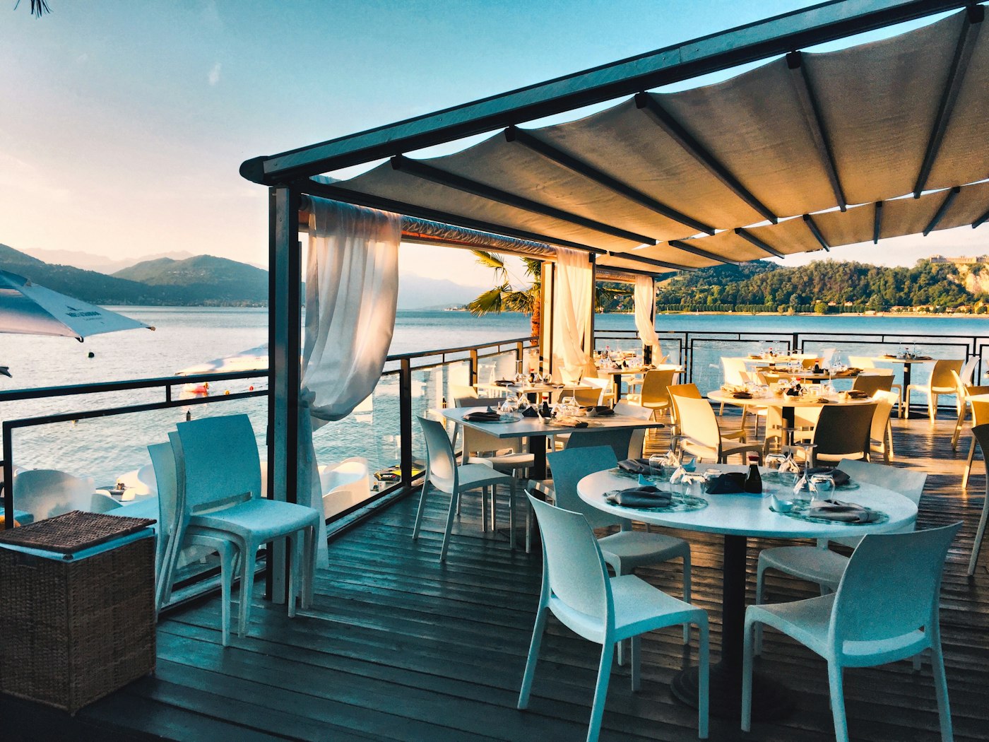 Salle du restaurant — tables nappées, lumière chaude, tomettes au sol