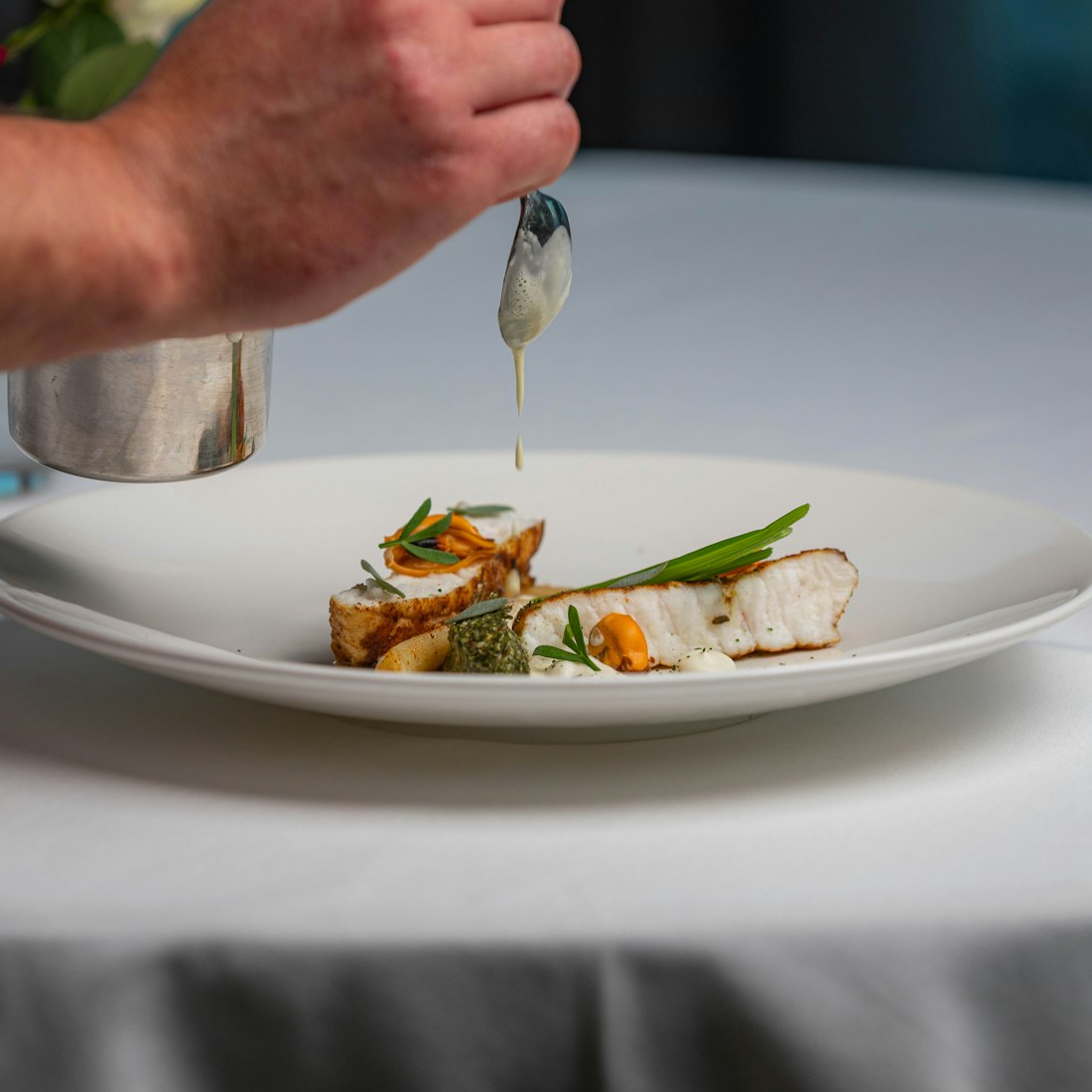 Filet de cabillaud dressé, condiment et jus monté à la cuillère par le chef