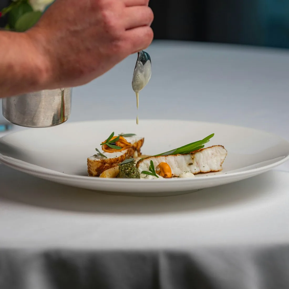 Filet de cabillaud dressé, condiment et jus monté à la cuillère par le chef